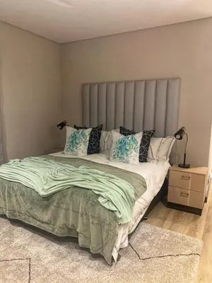 a bedroom with a large bed with green sheets and pillows at Walkerson Estate Country Home in Dullstroom