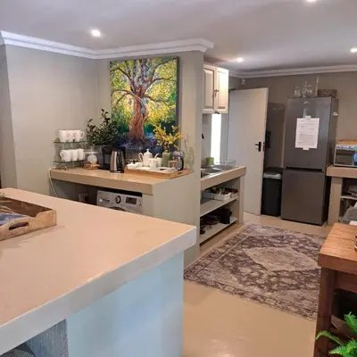 a kitchen with a painting of a tree on the wall at Kruger Tree Lodge in Marloth Park