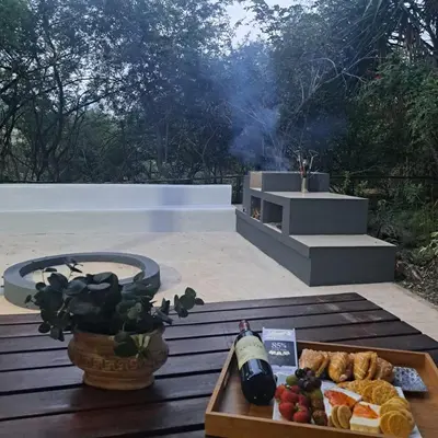 a table with a tray of food and a fire pit at Kruger Tree Lodge in Marloth Park