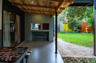 a patio with a wooden roof and a table at Gillford Alley luxury bachelor living in Benoni
