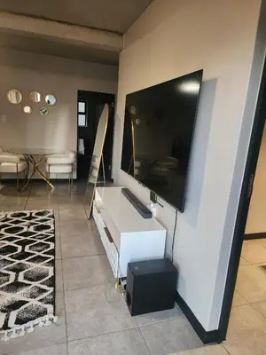a living room with a flat screen tv on a wall at The pentagon luxury in Midrand