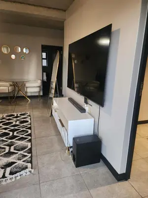 a living room with a flat screen tv on a wall at The pentagon luxury in Midrand