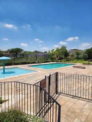 a swimming pool with a fence around it at The pentagon luxury in Midrand