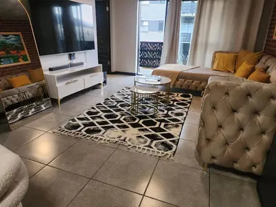 a living room with a couch and a table at The pentagon luxury in Midrand