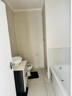 a white bathroom with a toilet and a sink at High End 93 On New Stay in Midrand