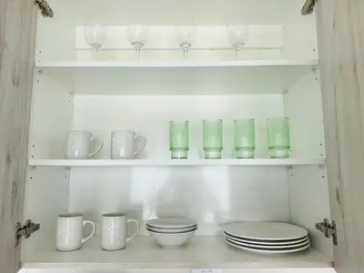 a cupboard filled with plates and cups and glasses at High End 93 On New Stay in Midrand