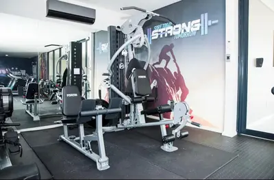 a gym with tread machines and a poster on the wall at High End 93 On New Stay in Midrand