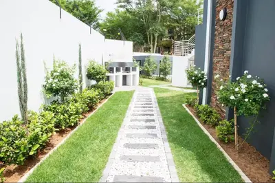 a garden with a stone pathway and grass at High End 93 On New Stay in Midrand