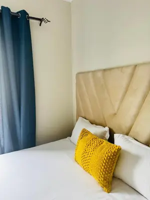 a bedroom with a bed with a yellow pillow at High End 93 On New Stay in Midrand