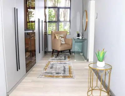 a living room with a chair and a table at Bayley Boutique Guesthouse & Hydro Spa in Benoni