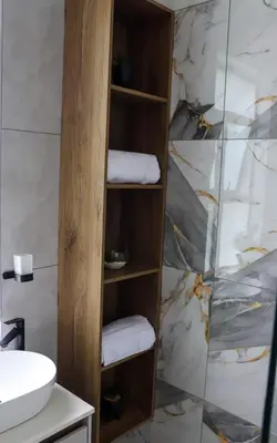 a bathroom with a wooden shelf with towels at Bayley Boutique Guesthouse & Hydro Spa in Benoni