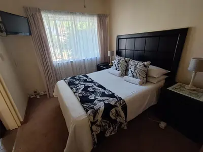 a bedroom with a large bed and a window at African Nights in Pretoria