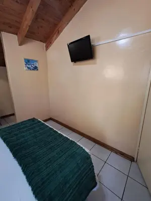 a room with a bed with a television on the wall at African Nights in Pretoria