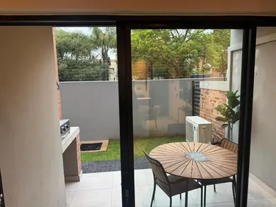 a patio with a table and chairs and a view of a yard at Waterkloof Park in Pretoria