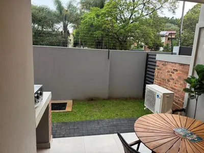 a small patio with a table and an umbrella at Waterkloof Park in Pretoria