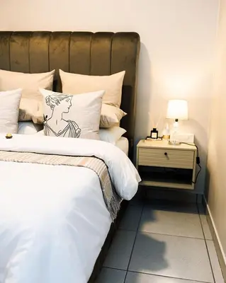 a bedroom with a bed and a side table at Mbombela Sunrise Retreat in Boschrand