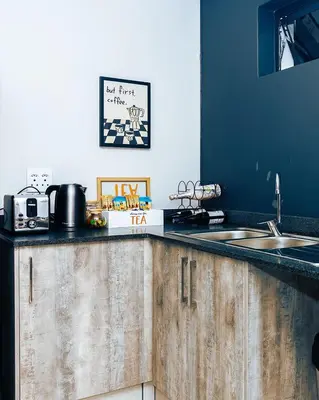 a kitchen with wooden cabinets and a sink and a counter top at Mbombela Sunrise Retreat in Boschrand