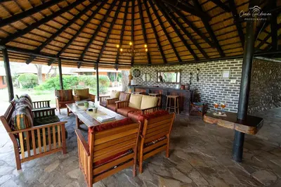 an outdoor patio with a couch and tables and chairs at Mohlabetsi Safari Lodge in Hoedspruit
