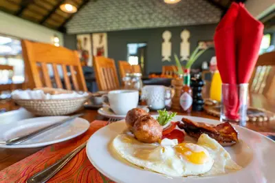 a plate of eggs and bacon on a table at Mohlabetsi Safari Lodge in Hoedspruit
