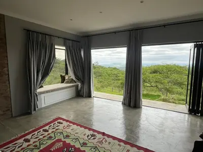 a large room with large windows and a rug at Hooggelegen Estate in White River