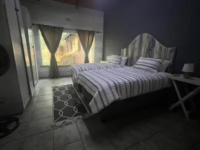 a bedroom with two beds and a window at Hooggelegen Estate in White River