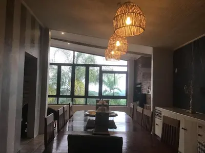 a dining room with a table and a large window at Hooggelegen Estate in White River