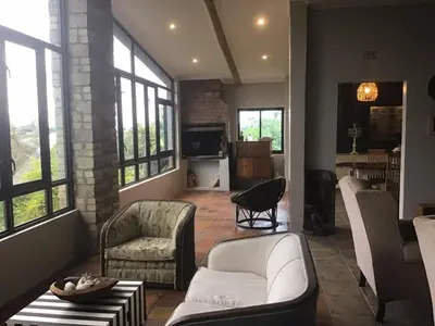 a living room with white furniture and windows at Hooggelegen Estate in White River