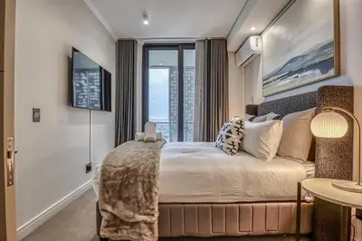 a bedroom with a bed with a large window at Stormside at Ellipse in Midrand