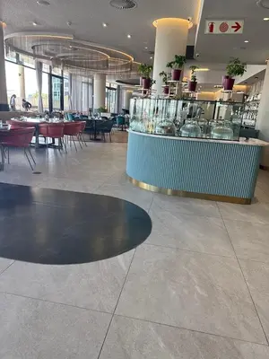 a restaurant with a counter and tables and chairs at Stormside at Ellipse in Midrand