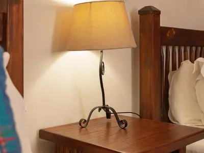 a lamp sitting on a table next to a bed at Awelani Eco Tourism Lodge in Masisi