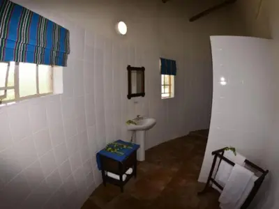 a white bathroom with a sink and a sink at Awelani Eco Tourism Lodge in Masisi