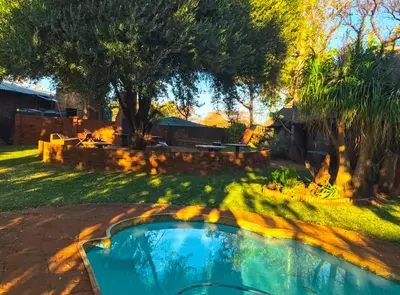 a small swimming pool in a yard with trees at Lapa Lê Lê Lodge in Ellisras