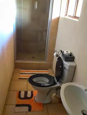 a bathroom with a shower and a toilet and a sink at Lapa Lê Lê Lodge in Ellisras