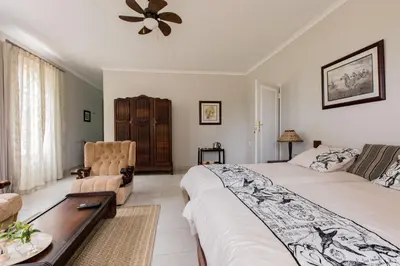 a bedroom with a bed and a couch and a table at Hacienda Destri Lodge in Wolwefontein