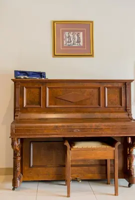a wooden piano sitting under a picture on a wall at Hacienda Destri Lodge in Wolwefontein
