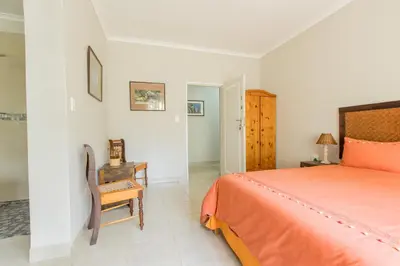 a bedroom with a bed and a chair and a table at Hacienda Destri Lodge in Wolwefontein
