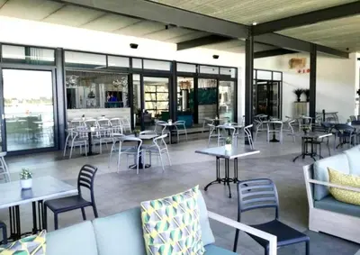 a restaurant with tables and chairs and windows at Cosy stay at The Blyde With Lagoon in Pretoria