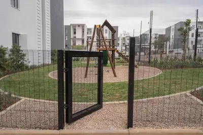 a fence with a playground in a park at Work, Travel, Relax in Pure Class in Midrand