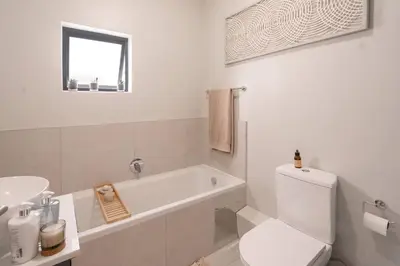 a white bathroom with a toilet and a sink at Work, Travel, Relax in Pure Class in Midrand