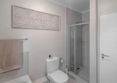 a white bathroom with a toilet and a shower at Work, Travel, Relax in Pure Class in Midrand