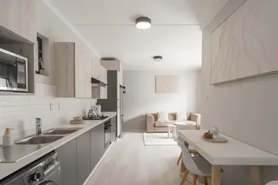 a white kitchen with a sink and a table at Work, Travel, Relax in Pure Class in Midrand
