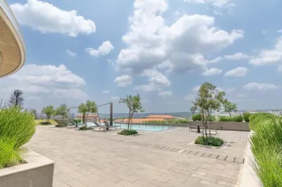 a patio with benches and a swimming pool at Ellipse Manscave Modern Luxury Apartment in Midrand