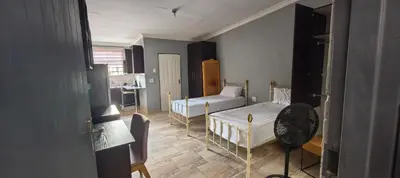 a small room with two beds and a bathroom at BlueHill Residence in White River