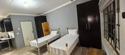 two beds in a small room with a bathroom at BlueHill Residence in White River