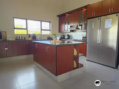 a kitchen with wooden cabinets and a stainless steel refrigerator at Mufasa's Den Zebula in Warmbaths
