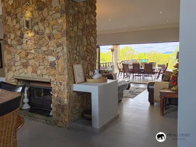 a living room with a stone wall and a fireplace at Mufasa's Den Zebula in Warmbaths