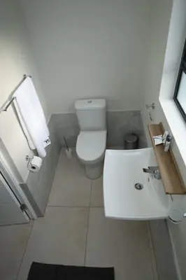 a white bathroom with a toilet and a sink at Yoga Luxury Lodge in Thohoyandou