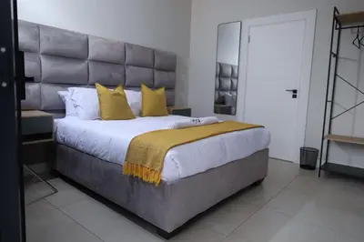 a bedroom with a large bed with yellow pillows at Yoga Luxury Lodge in Thohoyandou