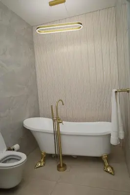 a bathroom with a white tub and a toilet at Yoga Luxury Lodge in Thohoyandou