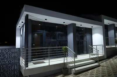 a building with a balcony with a plant on it at Yoga Luxury Lodge in Thohoyandou